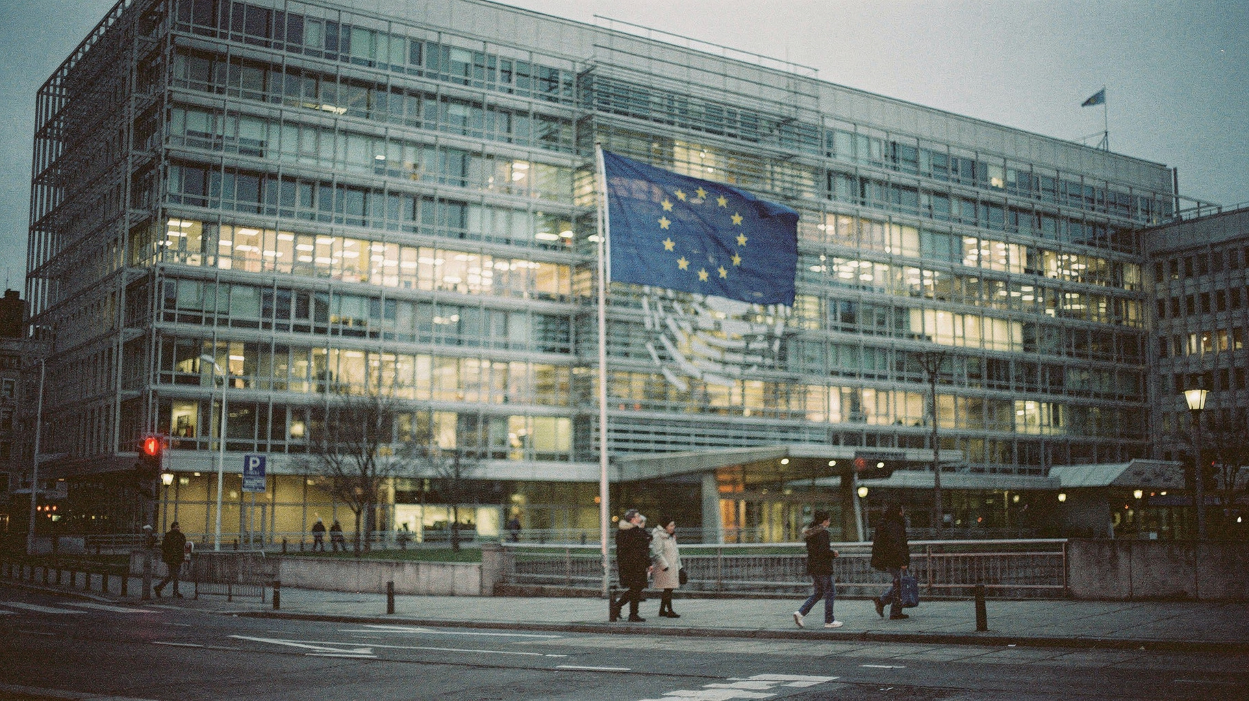 The EU flag outside the Berlaymont building in Brussels at dusk, where the AI Act was adopted.